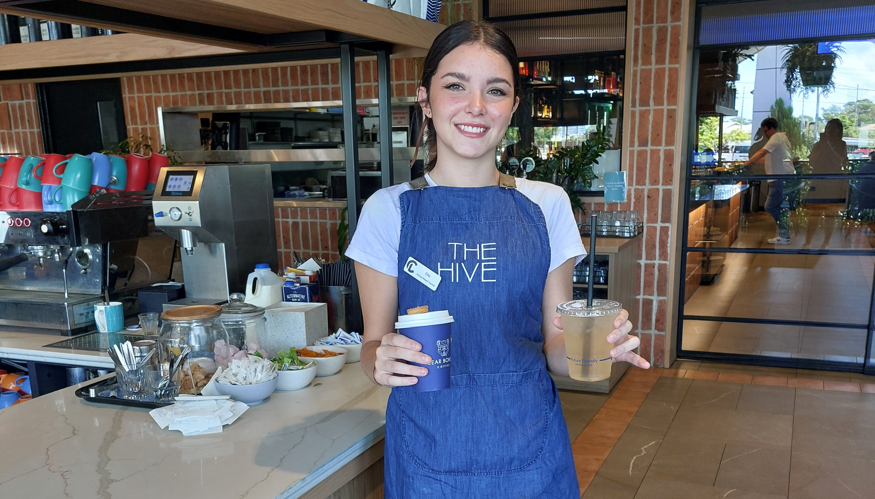 student preparing and serving drinks in a café setting, reflecting hospitality training and real-world work readiness